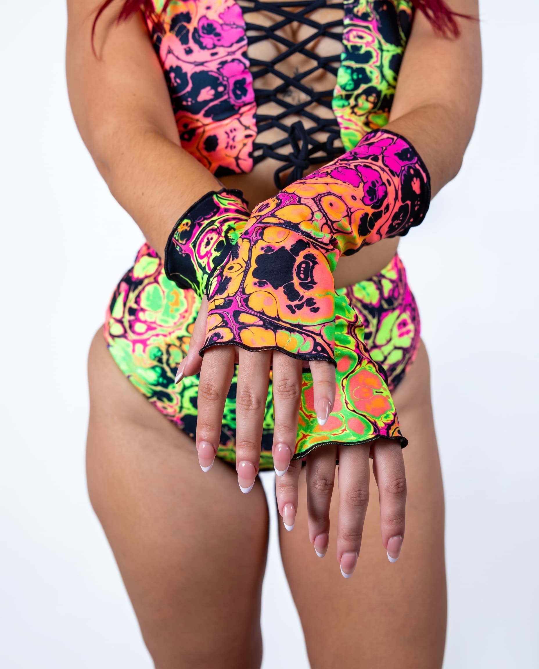 Intensity Gloves, close-up of crossed hands showing neon psychedelic print and black-trimmed wavy finger openings